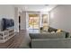 Living room with L-shaped sofa, hardwood floors, and sliding glass doors to backyard at 2242 Valdina St, Henderson, NV 89044