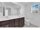 Bright bathroom featuring double vanity, framed mirror, dark cabinets, and natural light from the window at 2430 Bellinzona Pl, Henderson, NV 89044