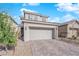 Two story home featuring a two car garage, stone driveway, neutral color, and low maintenance desert landscaping at 2430 Bellinzona Pl, Henderson, NV 89044