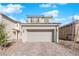 Two story home featuring a two car garage, stone driveway, neutral color, and low maintenance desert landscaping at 2430 Bellinzona Pl, Henderson, NV 89044