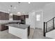 Kitchen with stainless steel appliances, island with sink, granite counters, dark cabinets, and decorative lighting at 2430 Bellinzona Pl, Henderson, NV 89044