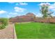 Landscaped backyard with a large grassy area and a brick wall at 2598 Iron Crest Ln, Las Vegas, NV 89138