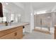 Modern bathroom with a walk-in shower, vanity with wood cabinets, and a large mirror at 2598 Iron Crest Ln, Las Vegas, NV 89138