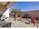 Cozy back patio with a grill, seating, and desert landscaping for outdoor enjoyment at 3025 Seaford Peak Dr, Henderson, NV 89052