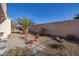 Relaxing backyard with desert landscaping, chairs, and a tall privacy wall at 3025 Seaford Peak Dr, Henderson, NV 89052