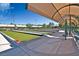 Outdoor bocce ball court with shade covering and seating area under a blue, partly cloudy sky at 3025 Seaford Peak Dr, Henderson, NV 89052