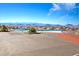 Outdoor pool with lounge chairs, umbrellas and mountain views on a sunny day at 3025 Seaford Peak Dr, Henderson, NV 89052