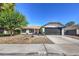 Single story home with gray garage door and red front door at 3425 Irv Marcus Dr, Las Vegas, NV 89108