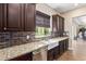 Kitchen features a farmhouse sink, granite countertops, and dark wood cabinets at 4063 Villa Rafael Dr, Las Vegas, NV 89141