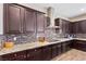 Modern kitchen boasts dark wood cabinets, granite countertops, and tile backsplash at 4063 Villa Rafael Dr, Las Vegas, NV 89141