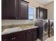 Laundry room with dark cabinets, granite counters, and appliances at 4063 Villa Rafael Dr, Las Vegas, NV 89141