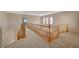 Upstairs hallway with wood railing and carpet at 6504 Birdcall St, North Las Vegas, NV 89084