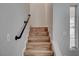 Modern stairs with wood risers and a dark metal handrail at 6536 Elk Creek Ln, Las Vegas, NV 89156