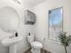 Simple bathroom with pedestal sink, toilet, and gray cabinet at 686 Last Dance Pl, Henderson, NV 89011