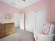 Bedroom with pink walls, glider, and double closets at 686 Last Dance Pl, Henderson, NV 89011