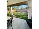 View of a large, grassy backyard, framed by a covered patio with outdoor seating at 7329 Restful Springs Ct, Las Vegas, NV 89128