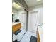 Bright bathroom featuring white marble floors, a wooden vanity, and mirrored closet at 7329 Restful Springs Ct, Las Vegas, NV 89128