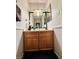 Cozy bathroom with a dark wood vanity and decorative mirror at 7329 Restful Springs Ct, Las Vegas, NV 89128