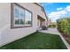 Landscaped backyard with artificial turf, paver patio, and a view of the home at 788 Flowing Meadow Dr, Henderson, NV 89014