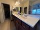 Bathroom featuring a double sink vanity with dark wood cabinetry and a large mirror at 8396 Waylon Ave, Las Vegas, NV 89178