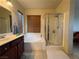 Relaxing bathroom features a soaking tub, a separate glass-enclosed shower, and wood-look blinds at 8396 Waylon Ave, Las Vegas, NV 89178