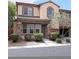 Two-story townhome with stone accents and landscaped front yard at 8396 Waylon Ave, Las Vegas, NV 89178