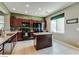 Well-equipped kitchen featuring dark wood cabinetry, an island, stainless steel appliances, and neutral colored tile flooring at 8396 Waylon Ave, Las Vegas, NV 89178