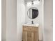 Modern bathroom with a round mirror and light wood vanity at 8509 Copper Falls Ave, Las Vegas, NV 89129