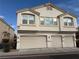 Two-story townhome with three-car garage and landscaped front yard at 8800 Roping Rodeo Ave # 103, Las Vegas, NV 89178