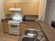 Well-equipped kitchen with gas range, double sink, and wood cabinets at 8800 Roping Rodeo Ave # 103, Las Vegas, NV 89178