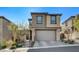 Contemporary two-story home featuring a neutral color scheme, attached two-car garage, and manicured landscaping at 889 Ariel Heights Ave, Las Vegas, NV 89138