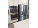 Close-up of stainless steel appliances including built in oven and french door refrigerator at 889 Ariel Heights Ave, Las Vegas, NV 89138