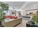 Open-concept living room with modern furnishings, tile flooring, and adjacent kitchen area at 889 Ariel Heights Ave, Las Vegas, NV 89138