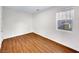 Simple bedroom with wood floors and a window at 9609 Rolling Thunder Ave, Las Vegas, NV 89148