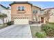 Two-story house with beige exterior, attached garage, and landscaping at 9609 Rolling Thunder Ave, Las Vegas, NV 89148