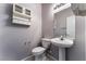 Clean bathroom with pedestal sink, toilet, and wall cabinet at 220 Emerald Vista Way, Las Vegas, NV 89144