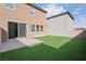 Artificial turf backyard with patio and two-story houses at 2932 Torreon Ln, Las Vegas, NV 89121