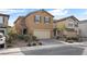 Two-story house with tan exterior, two-car garage, and landscaping at 2932 Torreon Ln, Las Vegas, NV 89121
