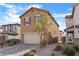 Two-story house with tan exterior, two-car garage, and landscaping at 2932 Torreon Ln, Las Vegas, NV 89121