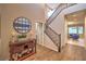 Welcoming entryway with wood-look tile, console table, decor, and staircase leading upstairs at 3213 Molinos Dr, Las Vegas, NV 89141