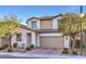 Exterior view of home with neutral colored stucco, tile roof, manicured front yard landscaping, and driveway at 3213 Molinos Dr, Las Vegas, NV 89141