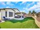 Manicured backyard with artificial grass, a covered patio, and a soothing hot tub at 3740 Corte Bella Hills Ave, North Las Vegas, NV 89081