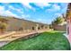 Manicured backyard with green grass, raised planters, and a privacy fence for added seclusion at 3740 Corte Bella Hills Ave, North Las Vegas, NV 89081