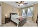 Comfortable bedroom with natural light, soft carpet, and a decorative ceiling fan at 3740 Corte Bella Hills Ave, North Las Vegas, NV 89081