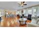 Open-concept living room with wood floors, large windows, and access to the kitchen and dining area at 3740 Corte Bella Hills Ave, North Las Vegas, NV 89081