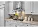 Kitchen detail showing gas cooktop, stainless steel hood, and light brown backsplash at 520 Summer Mesa Dr, Las Vegas, NV 89144
