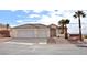 Two-car garage, desert landscaping, and a two-story home with a tile roof at 53 Flowering Desert Dr, Palm Gardens, NV 89039