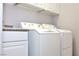 White cabinets and a granite countertop in a laundry room at 53 Flowering Desert Dr, Palm Gardens, NV 89039