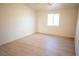 Simple yet cozy bedroom featuring hardwood floors and a bright window at 5841 Genoa Ave, Pahrump, NV 89060