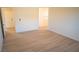 Bright bedroom with wood-look flooring, white trim, and a view into the hallway and an adjacent doorway at 5841 Genoa Ave, Pahrump, NV 89060